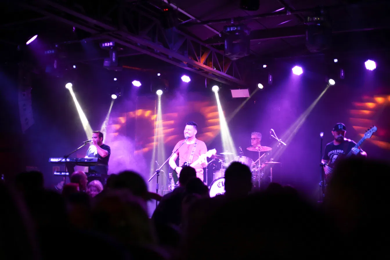 Banda no palco com luzes e plateia no Clay Highway Bar, bar de rock em Curitiba