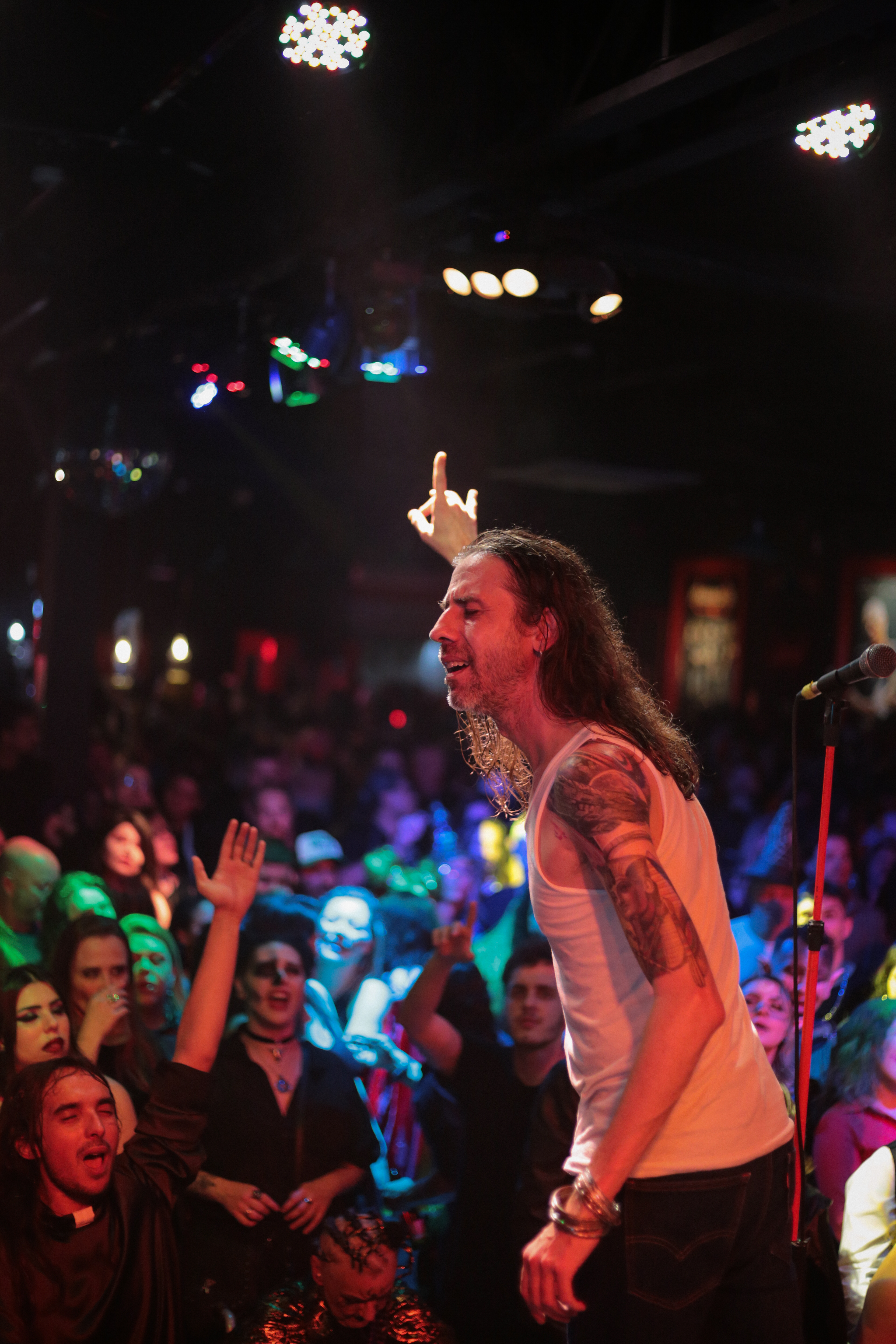 Vocalista cantando com o público fantasiado em noite de rock no Clay Highway Bar